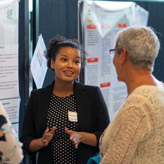 Photo is of an early childhood education student sharing her work during Capstone Presentation Day.