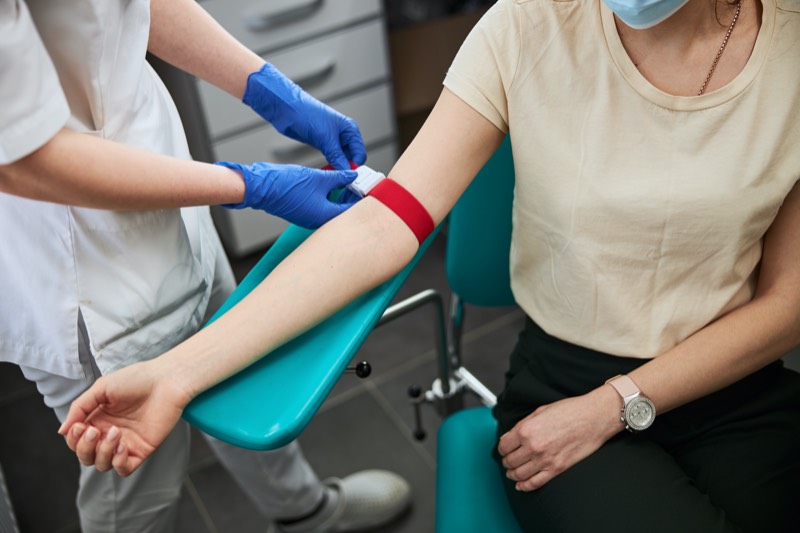 A phlebotomy tech prepares a patient for blood collection