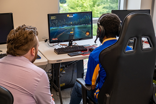 The Centralia College esports coach leans in to help an esports player during a match
